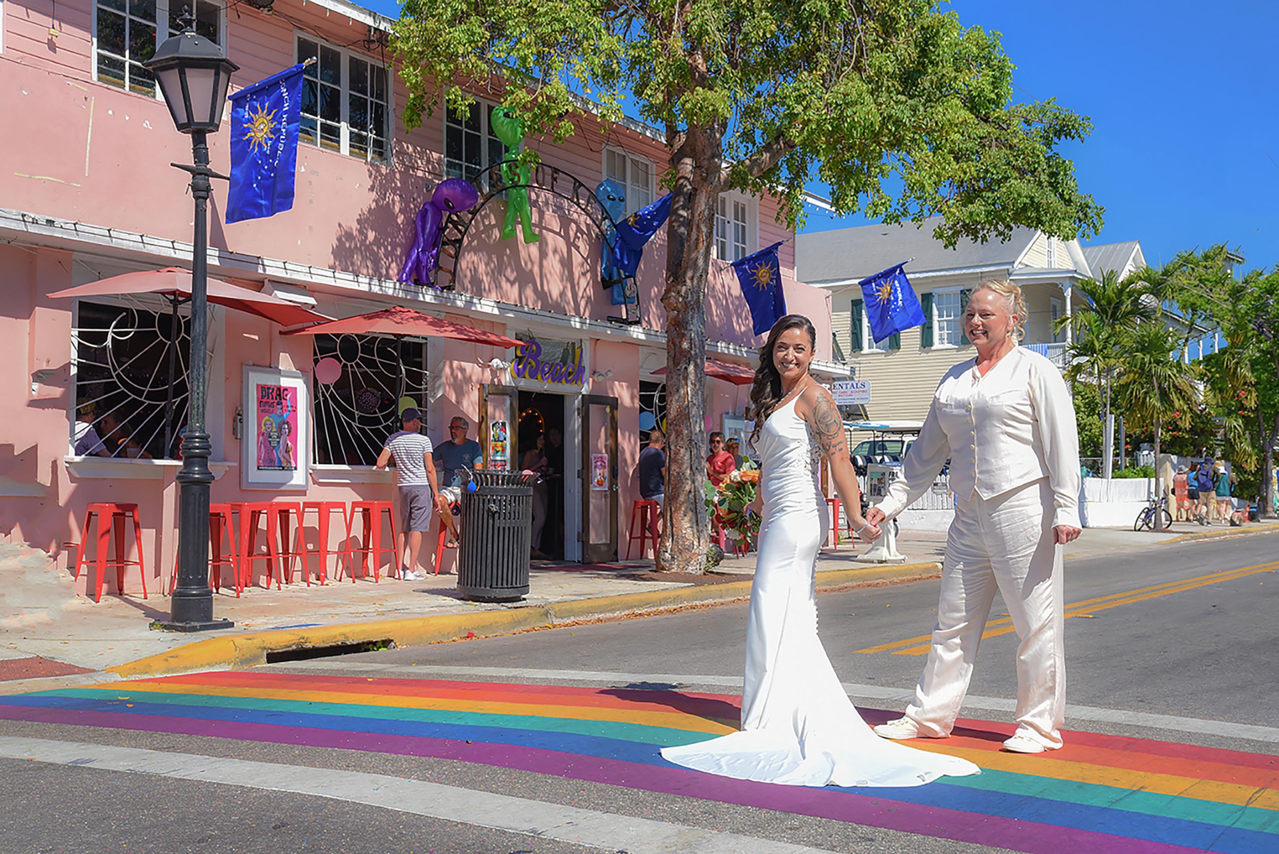 Two brides holding hands on the rainbow crosswalk in Key West
